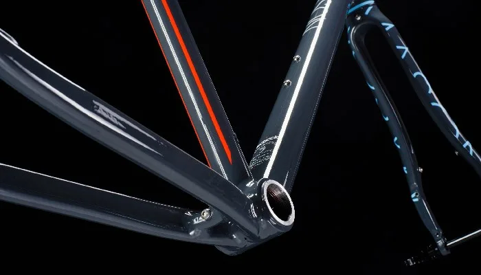 Decalco su telaio bicicletta. Striscia arancione sul tubo verticale e scritte su forcella
