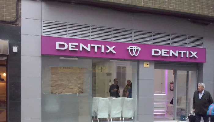 Insegna luminosa Dentix a lettere singole su pannello in plexiglass rosa